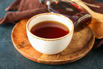 Bowl of tasty maple syrup on table, closeup
