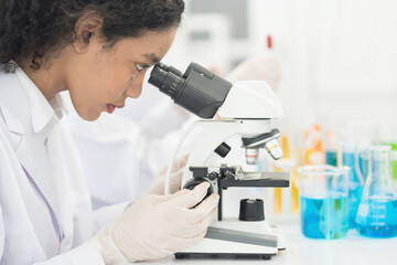 Close up woman scientist looking through microscope doing analysis for germs and bacteria of test...