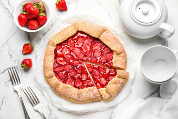 Sweet strawberry galette and fresh berries on light background