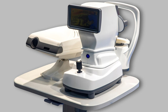 A white autorefractometer on a gray background is a device used in ophthalmology and optometry to assess the refractive ability of a patient's eye. Ophthalmic Glasses Eye lenses