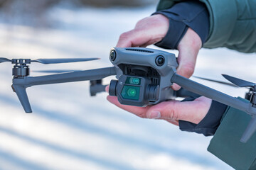 Quadrocopter, drone in hand against the background of snow