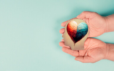 Holding a head with a colorful heart in the hands, symbol of love and positive emotion, charity and...