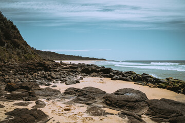 Fototapeta na wymiar Rocks on Australian beach with blue sky
