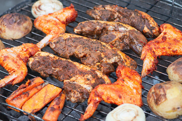 beef marinated steaks and chicken wings are cooked on the grill, barbecue