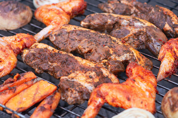 beef marinated steaks and chicken wings are cooked on the grill, barbecue