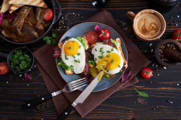 Tasty breakfast - fried egg toasts, bacon, tomatoes on wooden kitchen table
