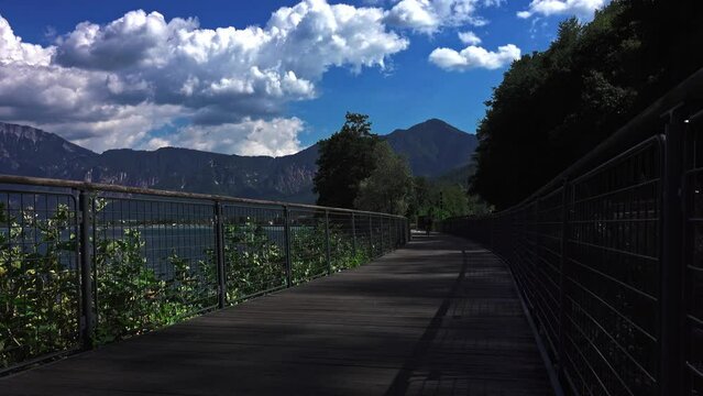 woman riding bicycle on mountain lake bike trail, in a suumer day. Travel lifestyle concept