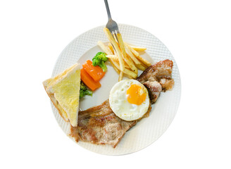 Top view of Pork Steak with fork, french fries, fried eggs, toast on white plate, focus selective