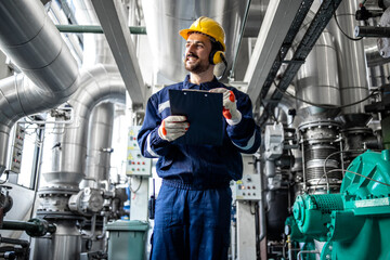 Professional employee standing in refinery producing petrochemicals.