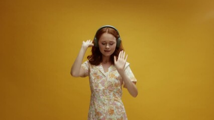 A young ginger white woman wearing headphones dancing having a good time enjoying the music - Powered by Adobe