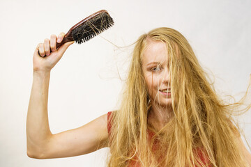 Blonde girl long blowing hair holds natural bristles brush - obrazy, fototapety, plakaty