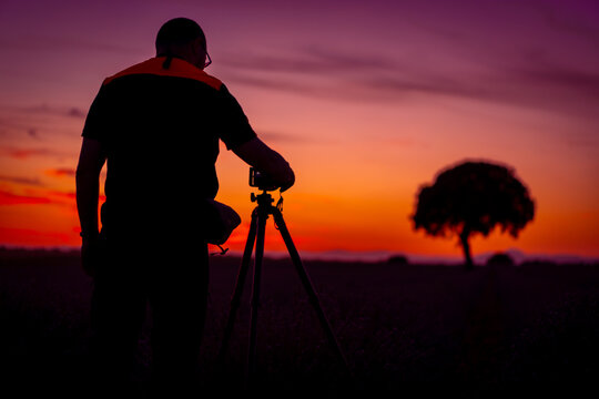 A photographer taking photos at sunset in a lavender field, nature photography