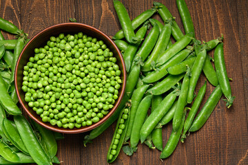 green sweet peas on a dark wooden background, still life, concept of fresh and healthy food