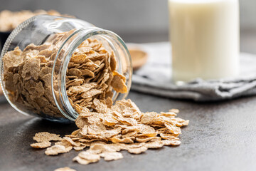 Whole grain cereal flakes. Wholegrain breakfast cereals in jar on kitchen table.