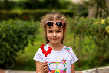 Little girl with red caramel lollipop cockerel © Anna