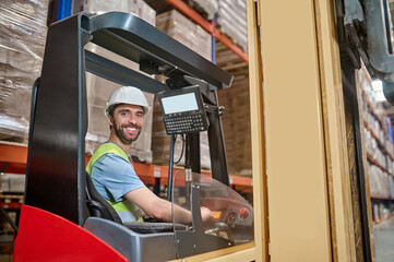 Joyous young lift truck operator at work