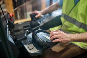 Skilled warehouse worker driving an electric forklift