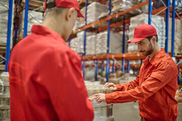 Two men unloading goods in the warehouse