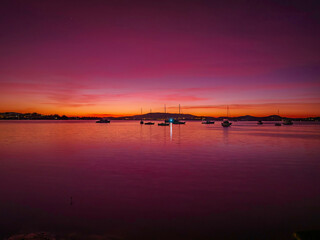 Obraz premium Pink dawn with boats and high cloud