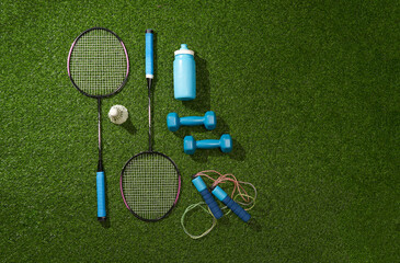 Set of different sports equipment on green grass background. Flat lay.