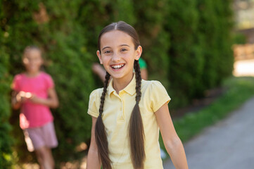 Laughing girl with pigtails and friends behind