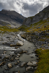 alpine hikers near mountain creek on Gemmi Pass in Valais