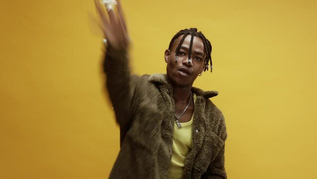 A young stylish black man booing and throwing popcorn