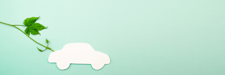 Silhouette of a white car on a green background with natural leaves. ecological fuel concept.