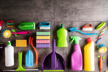 House  and office cleaning products. Colorful cleaning kit on gray tiles background.