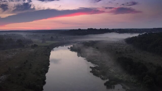 Drohnenaufnahme &uuml;ber neblichen Fluss vor Sonnenaufgang