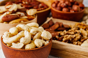 set of different nuts on a white wooden rustic background