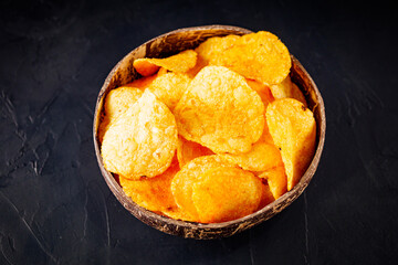 golden crispy potato chips on a dark background