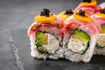 delicious sushi rolls on a black stone background - obrazy, fototapety, plakaty