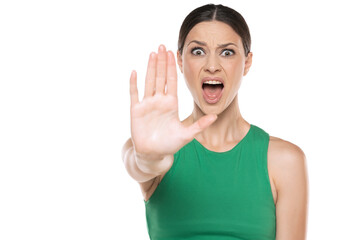 a young screaming woman in a short green shirt with stop hand  on white background