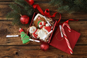 Christmas cookies in gift box and festive decor on wooden table, flat lay. Advent calendar