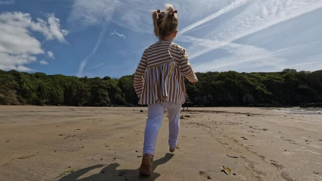 Toddler run over sunny beach