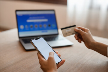 woman hands using smartphone and laptop computer for online shopping at home, Hand holding mobile phone with Payment Detail page display and credit card, online shopping concepts.