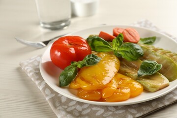 Delicious grilled vegetables with basil on white wooden table, closeup