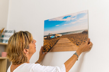 Mature woman hanging a very nice picture.
