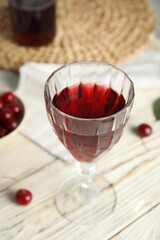 Delicious cherry wine with ripe juicy berries on white wooden table