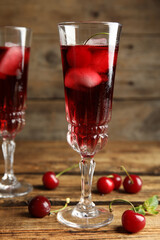 Delicious cherry wine with ripe juicy berries on wooden table