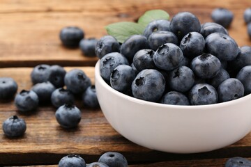 Tasty fresh blueberries on wooden table, closeup