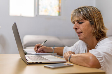 Adult woman at work, taking notes in her diary.