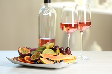 Delicious exotic fruits and wine on white table