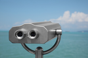 Metal tower viewer installed near sea. Mounted binoculars