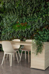 Green living room with chairs and table, vertical garden - stock photo