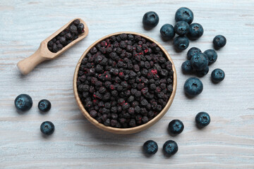 Fototapeta na wymiar Freeze dried and fresh blueberries on white wooden table, flat lay