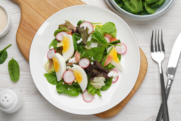 Delicious salad with boiled egg, radish and cheese served on white wooden table, flat lay
