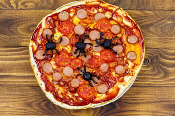 Halloween pizza with spiders on wooden table. Top view
