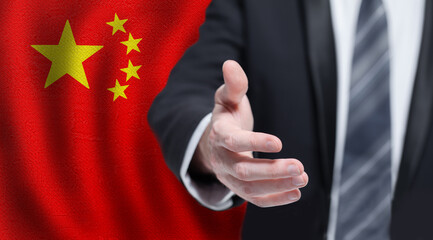 Chinese business, politics, cooperation and travel concept. Hand on flag of China background.